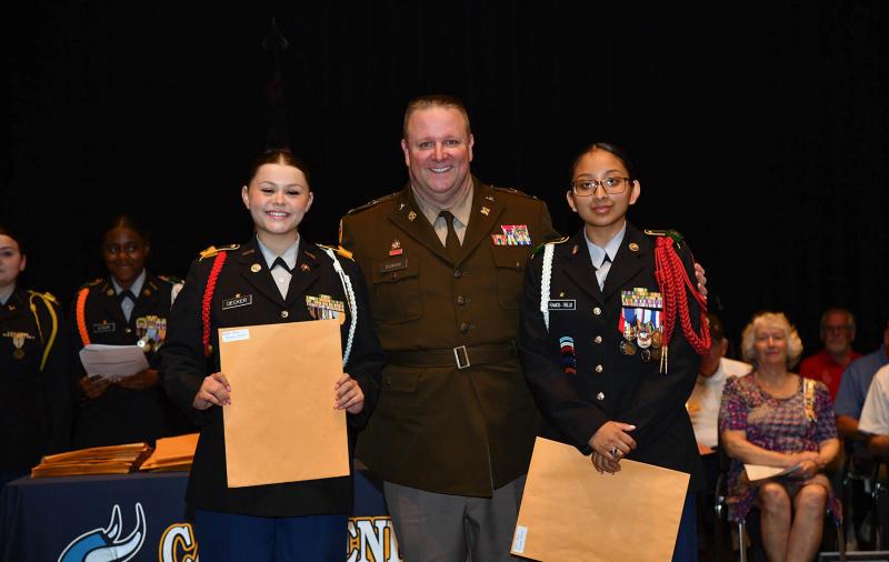 Col. Edward Dowgin presents the Major Angela Marie Erale Scholarship to cadets Gianna Decker and Jazmine Ramos-Trejo.