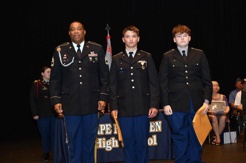 Sgt. First Class Richard Hurt presents the Army Instructor Medal to cadets Ronin Chmelewski and Ryan Rimmer.
