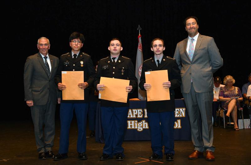 Maj. Gen. Fran Mahon and Andrew Coulter present the JROTC Good Conduct Medal to cadets Abimael Perez-Perez, Darius Davis and Gavin Davis.