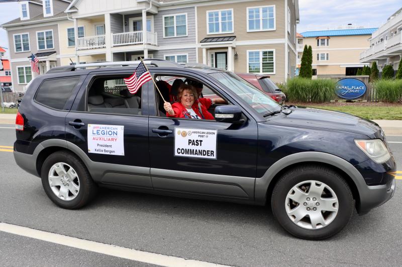 Kellie Bergen, American Legion Auxiliary Post 17 president, waves a flag as she makes her way to the post home.