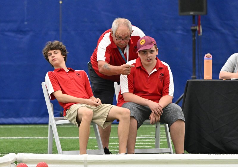 Getting instructions from coach Chuck Wineland are athletes Xavier Zimmer, left, and athlete Christopher Stone.