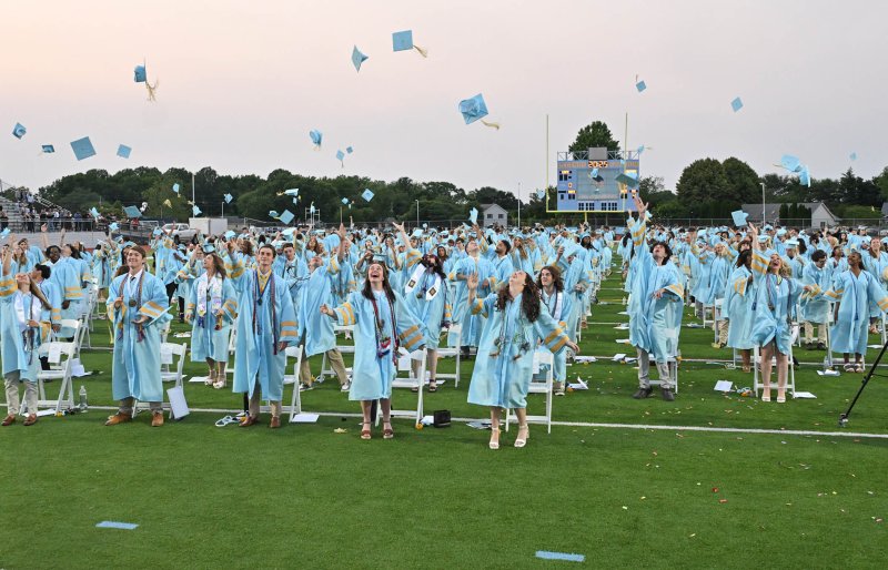 Members of the Cape Henlopen Class of 2025 toss their mortarboards after their graduation is confirmed.