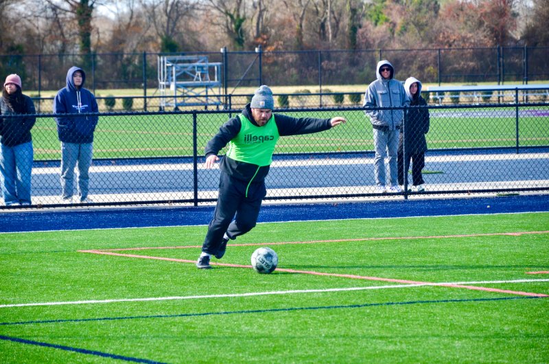 Sussex Academy head coach R.J. Dina boots the ball.