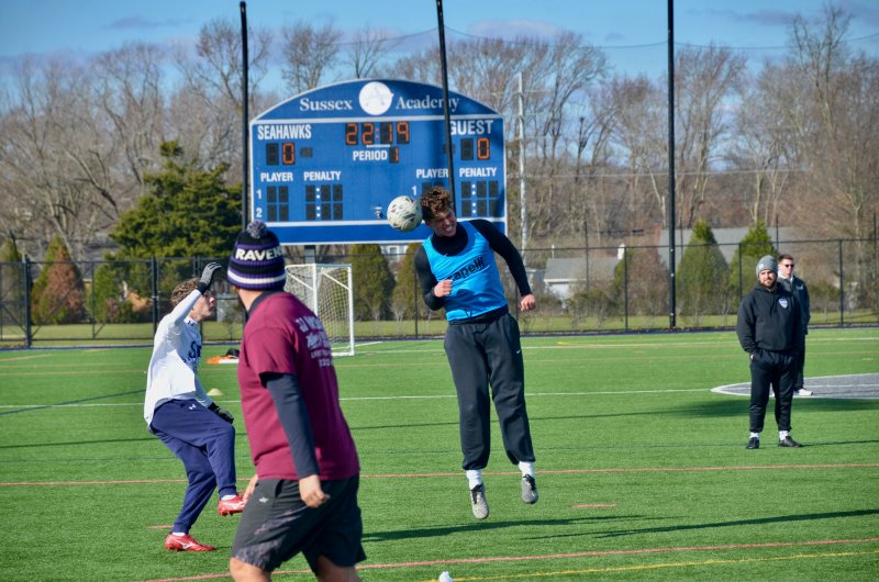 Class of 2025 graduate CJ Norton heads the ball past senior Chase Ballinger.