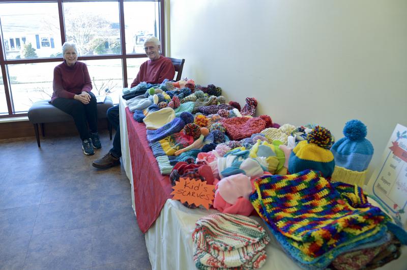 Mary and Jerry Graczyk attend the table of knitted hats and scarves.