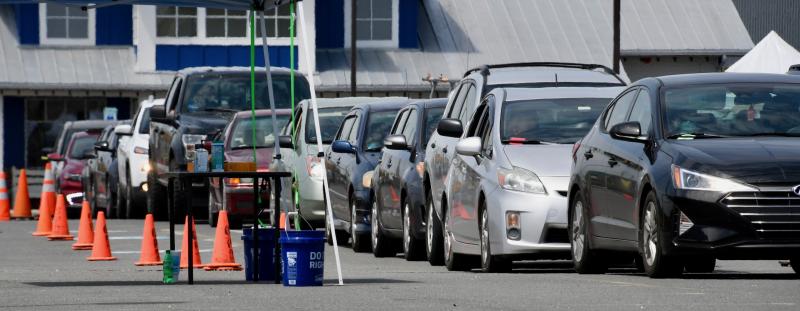 A long line of cars moves through the process of screening and testing in the parking lot of JD Shuckers and the Sussex County VA community-based outpatient clinic in Georgetown.