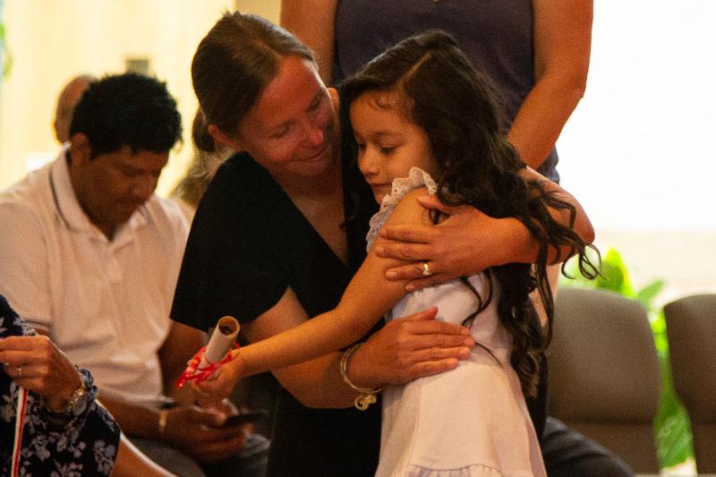 Teacher Carrie Dare and Penguin Class graduate Victoria Stogie give each other a hug.