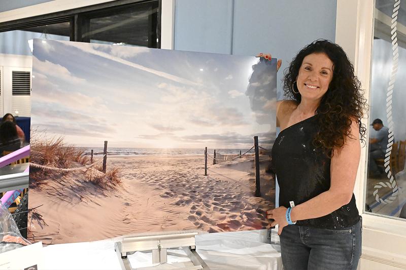 Susan McLean of Susan McLean Photography stands with her photo that was up for auction.