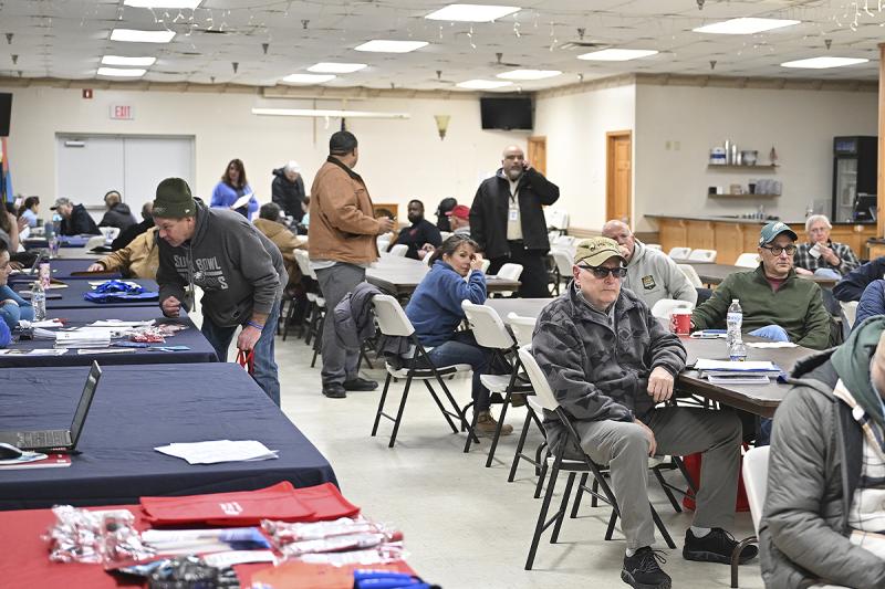Multiple tables are set up to provide information and services to the veterans who attended.