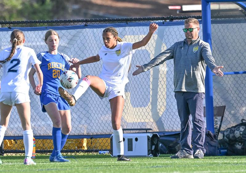 Cape junior Ava Brown, center, controls a high bouncer in front of the Vikings’ bench during the 2-0 loss to the Riders. DAN COOK PHOTOS