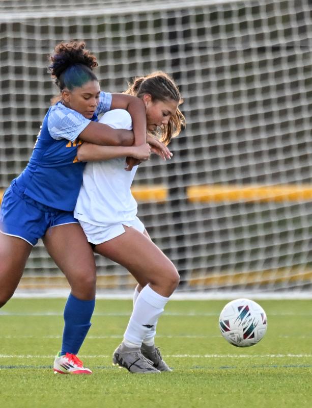 Cape freshman Kailey McMahon gets wrapped up by the Riders’ Ky'Leiah LaRue.