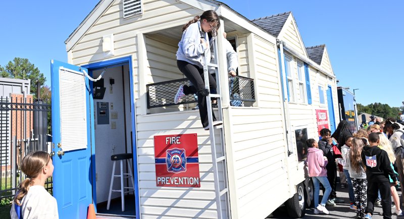 Harper Wood of Georgetown Elementary climbs down an escape ladder on the Dagsboro fire safety house.