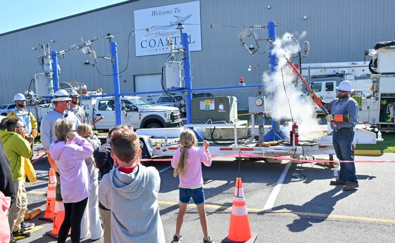 Elementary students cover their ears as a loud boom sounds when Delaware Electric Co-Op Lead Lineman Mike Rementer sets off an electric breaker simulating foreign contact to a high-voltage line that would blow a fuse. DAN COOK PHOTOS