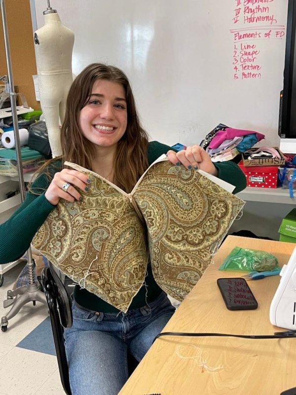 Former Cape fashion program student Reagan Buehler shows off her in-progress zipper pouch during a 2023 project.