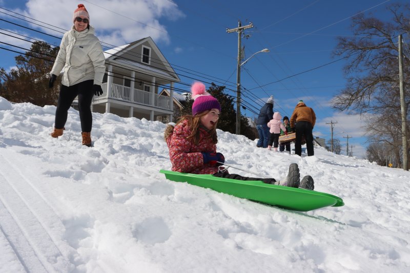 Charlotte Levin sleds down one of Lewes’ few hills, at Canalfront Park Feb. 24 as her mother Lauren Levin watches nearby.