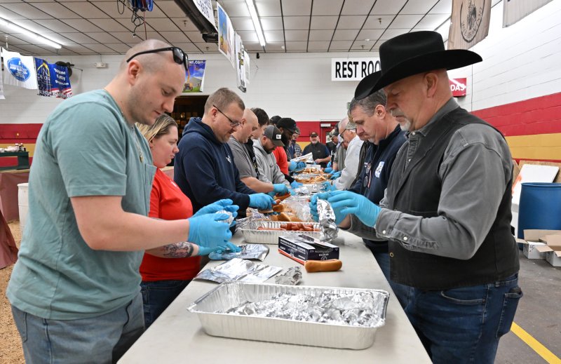 Sheriff Robert Lee, right, and Georgetown firefighter Spencer Sukar wrap hot dogs for the guests. The event featured 1,600 hot dogs.