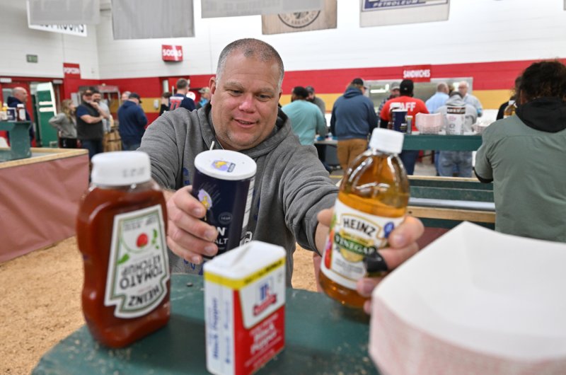 Georgetown firefighter Jamie Locklear loads up the condiments before the crowd gets into the Georgetown fire hall.