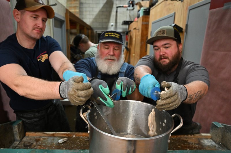 Shucking oysters are (l-r) James Hanes, James Hitchens Sr. and James Hitchens Jr.