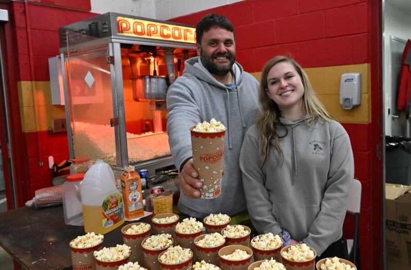 Ricky Hudson and Rachel Shultz serve up some tasty popcorn. The event used 30 pounds of popcorn for the event.