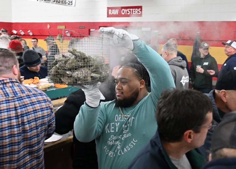 Jevon Harmon carries a basket of steaming oysters to an awaiting table.