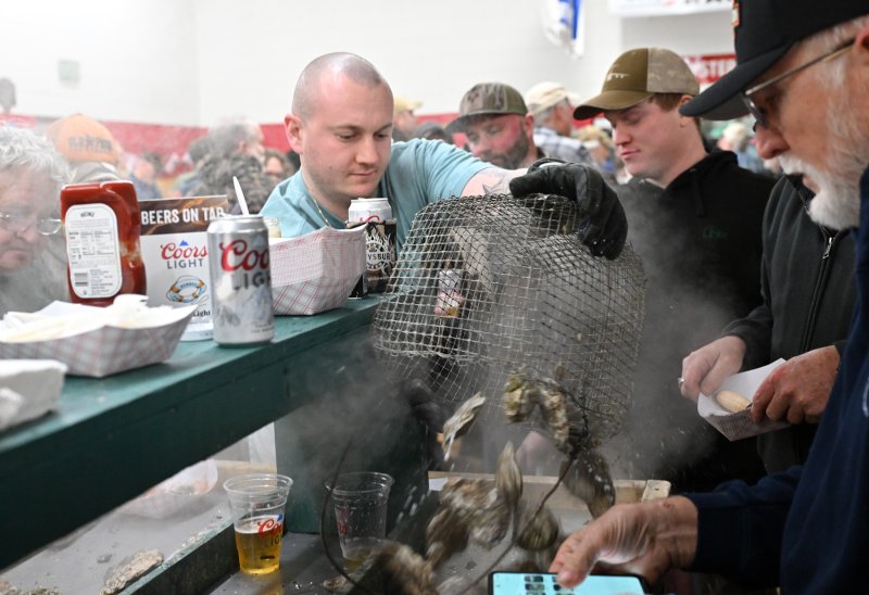 Spencer Sukar unloads a basket of steaming saltwater bivalve mollusks.