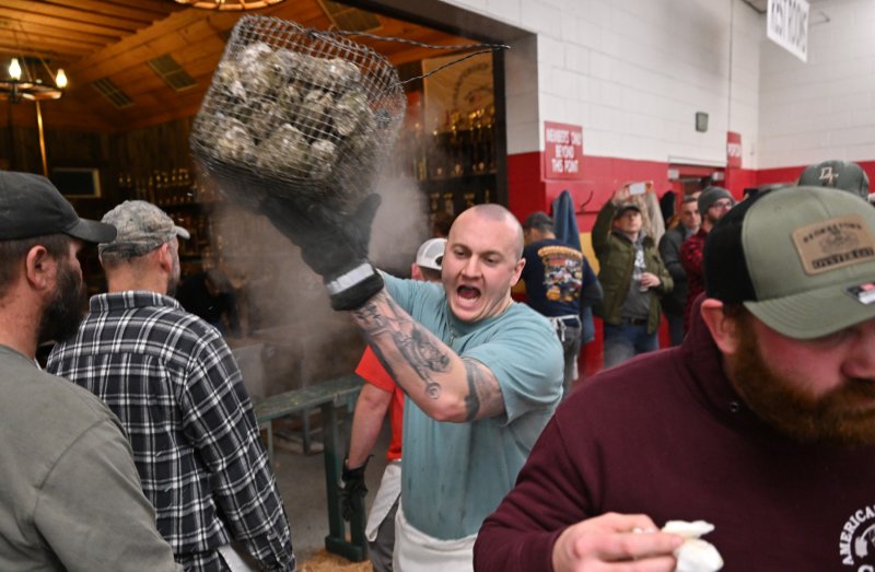 Georgetown fireman Spencer Sukar carries a basket of steaming oysters to a table of hungry, knife-welding mollusk lovers. DAN COOK PHOTOS
