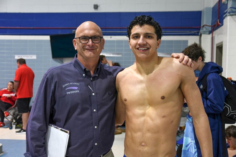 Sussex Academy’s Christian Wright, right, gets a congratulatory hug from coach Tom Martiner.