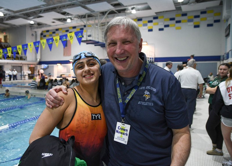 Cape junior Mia Jaoude gets a congratulatory hug from an emotional Cape coach Bill Geppert. Jaoude is the first Cape individual swimmer to stand atop the podium. Geppert was also named the DIAA Girls’ Coach of the Year. DAN COOK PHOTOS