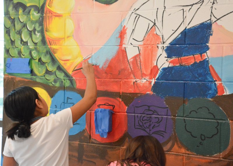 Giving the Viking a blue cape to match school colors on the mural is Love Creek Elementary student Dorcas Ambrosio Molina. SUBMITTED PHOTOS