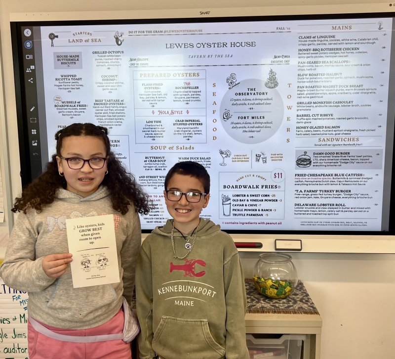 Winner of the logo design contest, Ana Morales-Henriquez, left, and Marlon Wilkinson-Perez, who spearheaded the contest idea, are shown with the Lewes Oyster House children’s menu and main menu. SUBMITTED PHOTOS