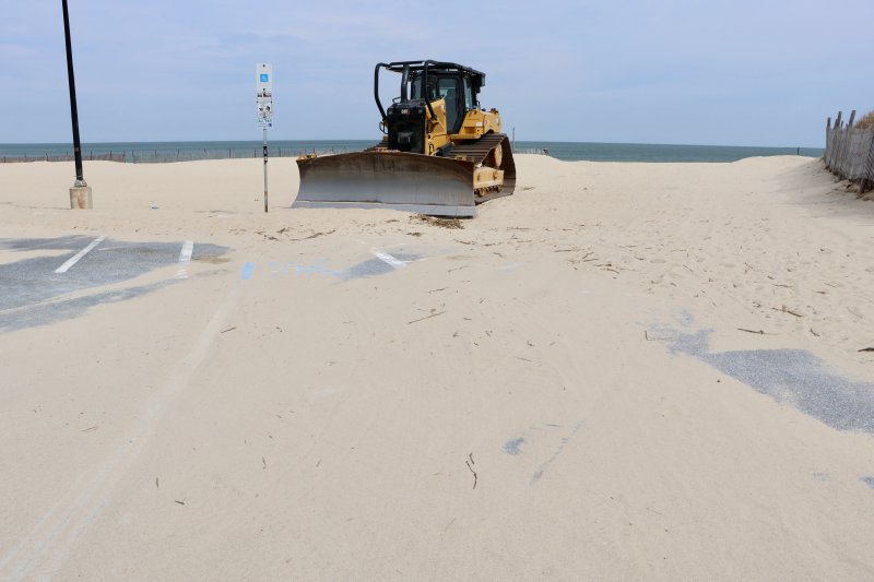 A single bulldozer and some smaller equipment remain in the Savannah Beach parking lot. There is still sand there that has to be removed.