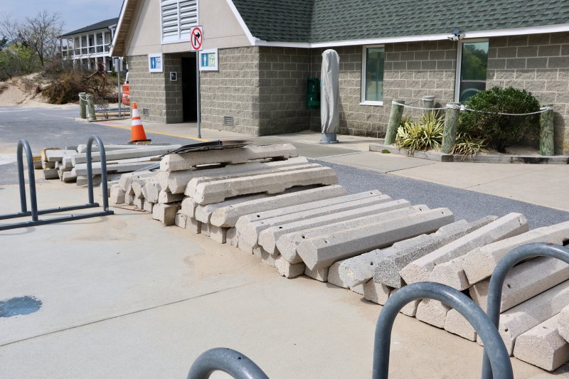 Parking curbs are piled up near the lifeguard headquarters building.
