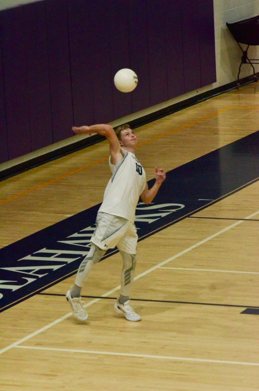 Sussex Academy senior Jerry Green serves the ball.