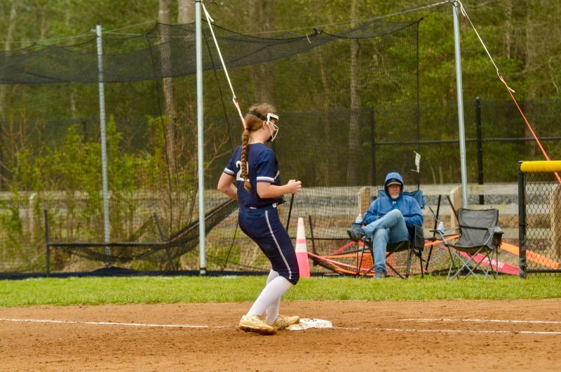 Sussex Academy junior Caroline White steps on first base.