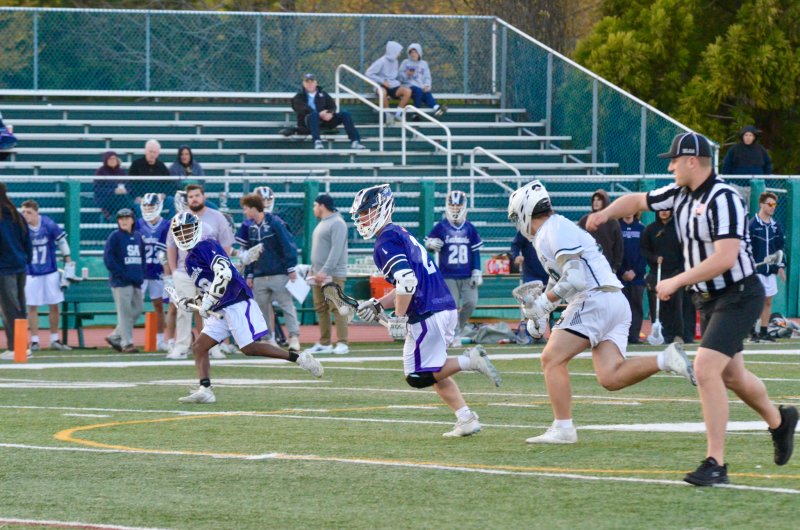 Sussex Academy junior Taco Meszaros heads toward the box after winning a face-off.