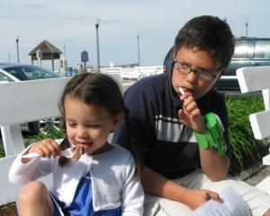 Ty Solloway looks on while younger sister Quinn enjoys one of her favorite flavors, Blue Ribbon Chocolate.