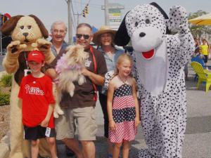 Doggies at the Beach owner Jim Reiter holds the first costume winner, Molly. Shown in back are (l-r) Biscuit and Bert and Bev Qiuinlan. In front are Casey Borell, Reiter, Molly, Maddie Borell and Freckles. BY STEVEN BILLUPS