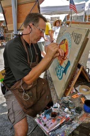 Mark Zilliox of Owings, Md., works on one of his wooden signs with an Eastern Shore theme. BY RON MACARTHUR