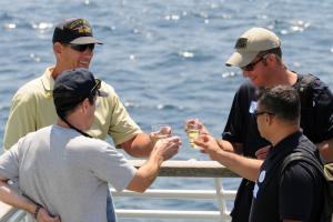 Former crew members of the decommissioned warship makes a final toast in her honor just before sinking. They are (top left, clockwise) Lee String, Kevin Sorenson, Albert Zampirri and Kirt Sorenson.