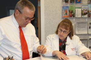 Dr. Kenneth Sunnergren, MD, PhD, and Peggy Bixler, NP, confer on a patient's care. BY BILL MARTIN