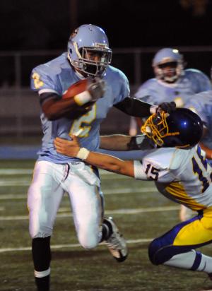 Cape's TK Saez stiff-arms Central's Joshua Swift and runs for a short gain. BY DAN COOK