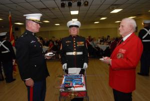 The cutting of the Marine Corps cake is a formal ceremony. The first pieces of cake are given to the oldest and youngest Marines present. Shown are (l-r) youngest Marine Major Frank Ryman, Indian River High School Marine JROTC Commander; Cake Escort First Sgt. Ret. Bill Kandarri; and oldest Marine John Watson. BY STEVEN BILLUPS
