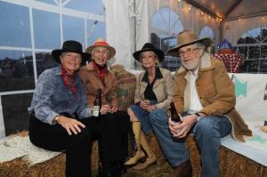 Under the tent and on the hay bale benches are neighbors Ann McNeil, Barbara Kelly, Midge Smith and Carl Wisler. BY STEVEN BILLUPS