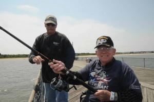Wearing his Post 17 T-shirt, George Scofield gets some help with his line from Post 17 volunteer Bud Slivar. Scofield, wearing his airborne hat, made 269 jumps while in the service. BY STEVEN BILLUPS
