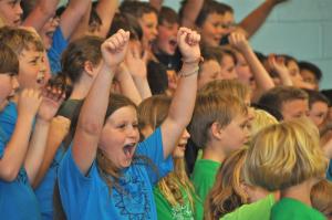 Madison Swiderski raises her hands during the spring chorus concert. BY RON MACARTHUR