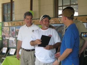 Rick Starr receives the award for the Mobile Surf Fishermen. The group was honored as an outstanding volunteer for their dedication to the annual beach grass planting events for more than 15 years. Shown with Starr, center, are Shawn Garvin of the EPA, left, and Gov. Jack Markell. BY RACHEL SWICK MAVITY