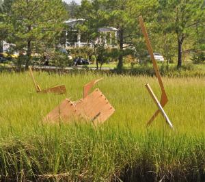Plywood and other lumber sticking upright in a nearby marsh is evidence of the intensity of the wind that hit the Bayside community. BY RON MACARTHUR