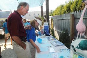 MERR volunteer Jackson Gingrich and Nancy Carney browse the several silent auction items donated by local businesses. BY STEVEN BILLUPS
