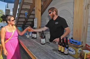 Andrew Greely, a Dogfish tour guide, provides a sample of Dogfish beer to Joan Greely. BY STEVEN BILLUPS