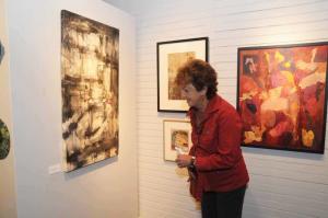 Admiring the work of Lee Wayne Mills, “Whispers Outside the Circle of Fire,” is Sally Hastings. BY STEVEN BILLUPS
